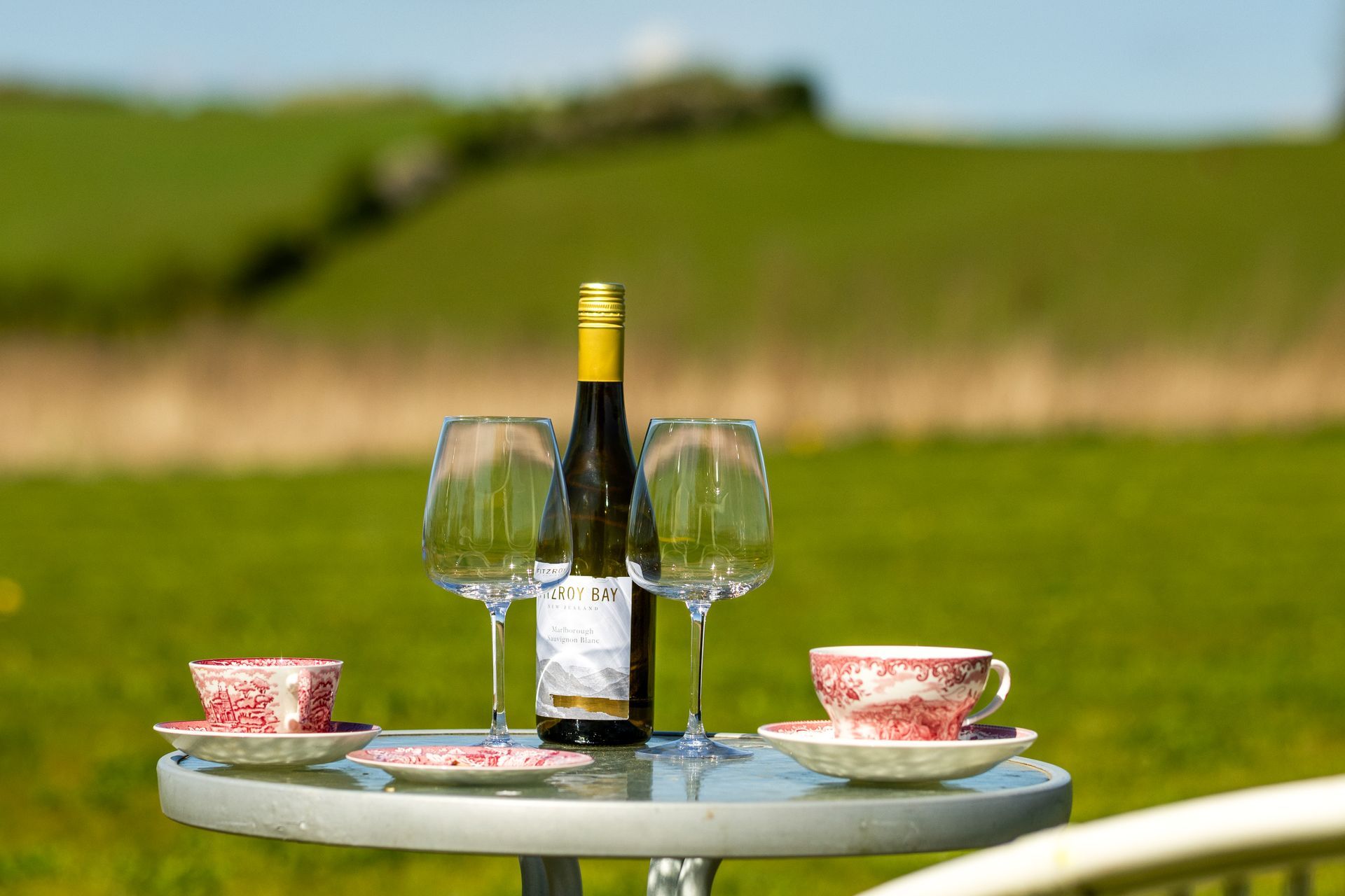 A table with a bottle of wine and two glasses on it.