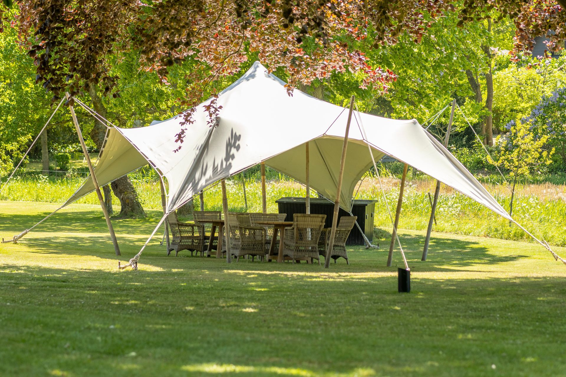 A large white tent is sitting in the middle of a grassy field.