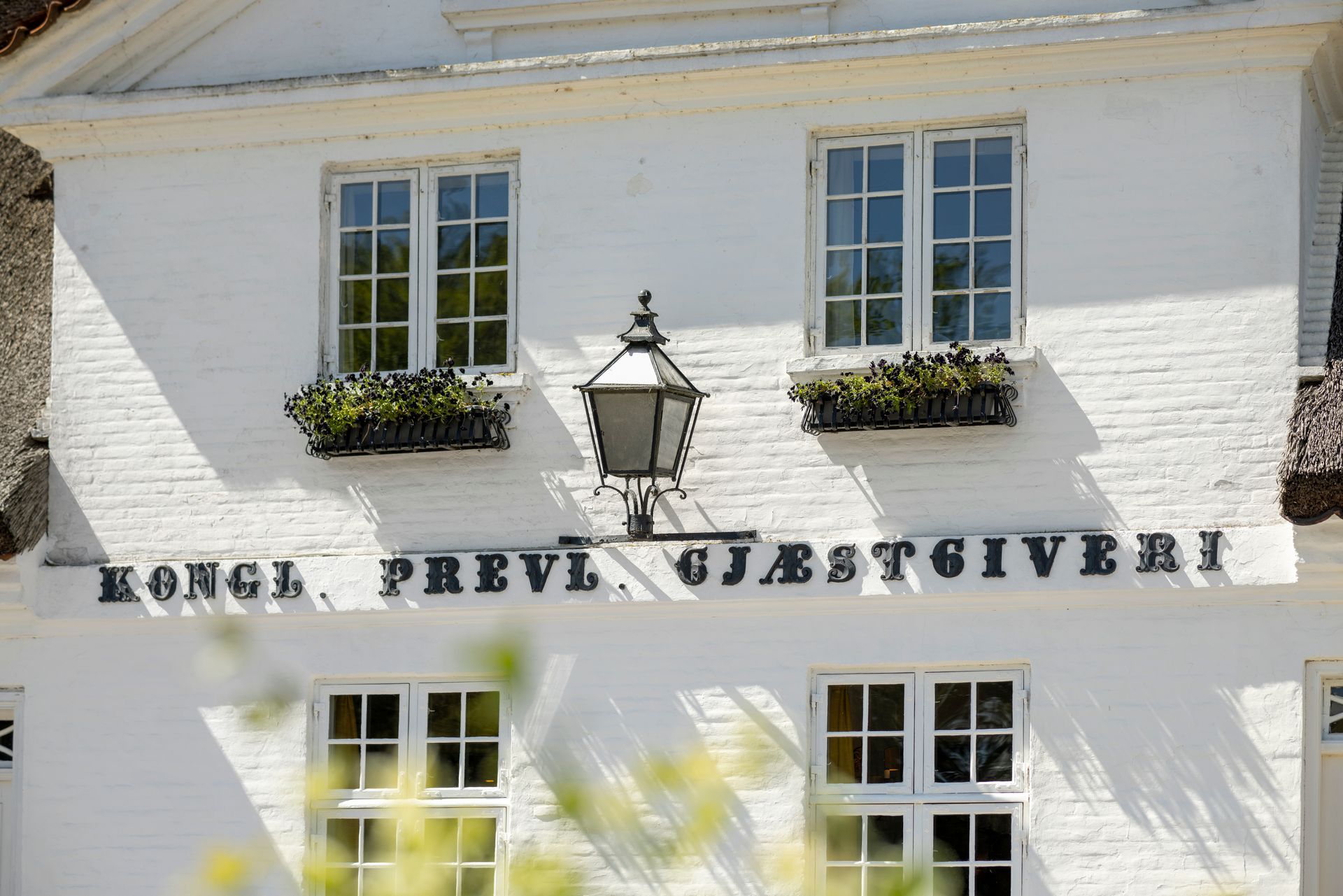 A white building with a sign that says kongl previ