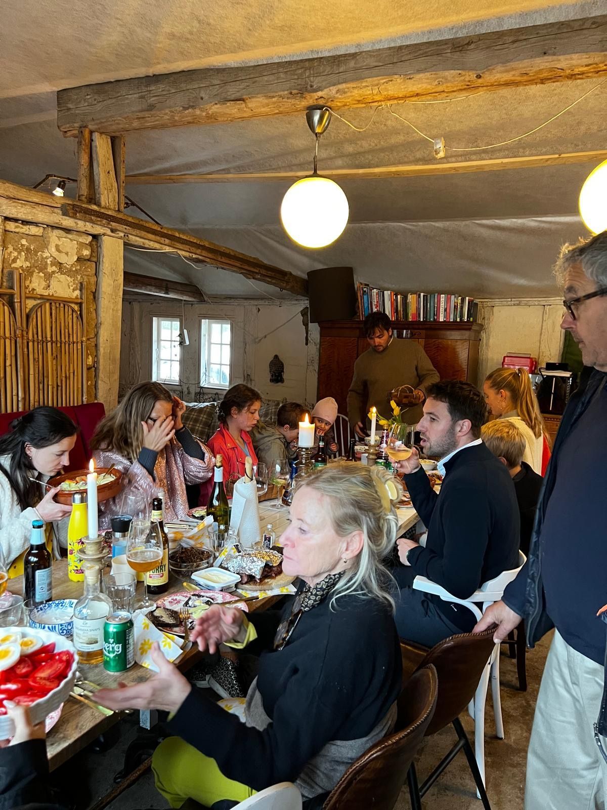 A group of people are sitting at tables in a restaurant eating food.