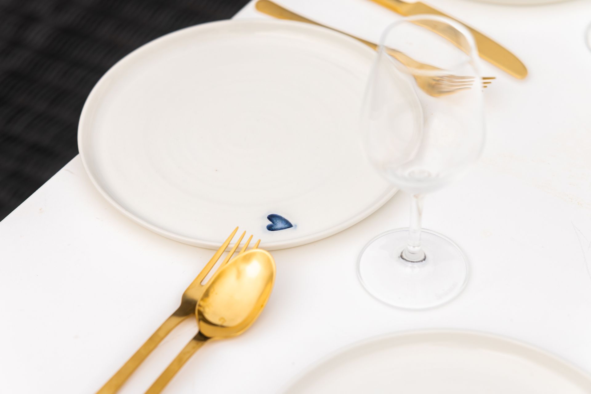 A white plate with a gold fork and spoon on it