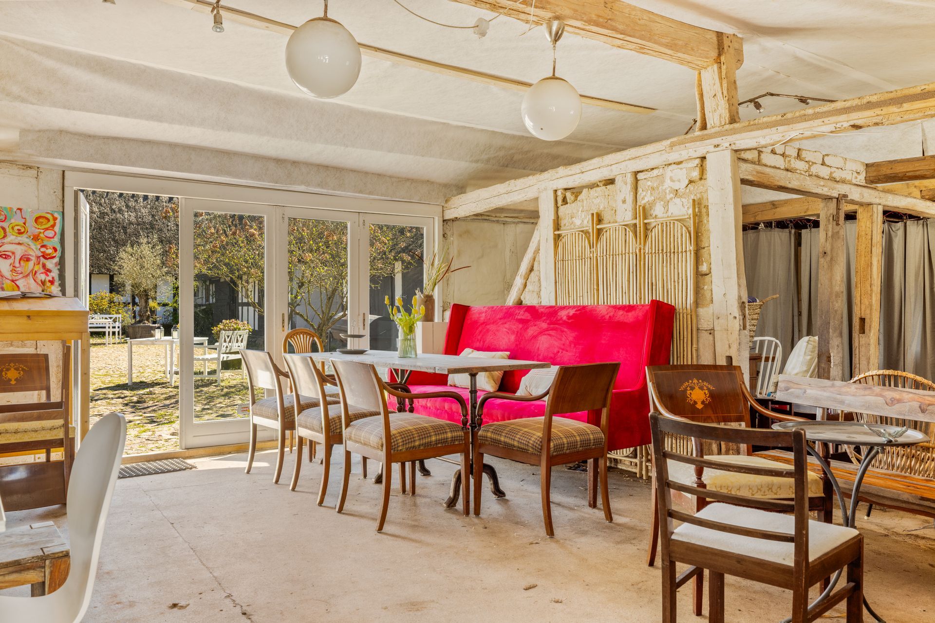 A restaurant with tables and chairs and a red couch.