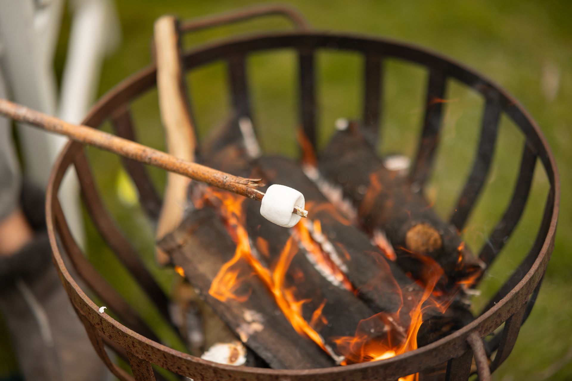 A person is roasting marshmallows over a fire pit.
