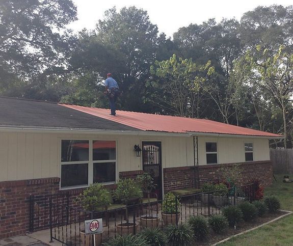 A man is working on the roof of a house