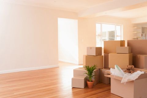 Boxes stacked on wooden floor of new house
