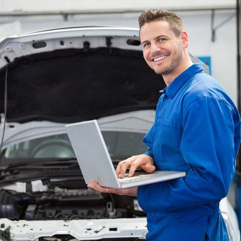 Car Repair — Worker Using Laptop to Check the Vehicle in Lockport, NY