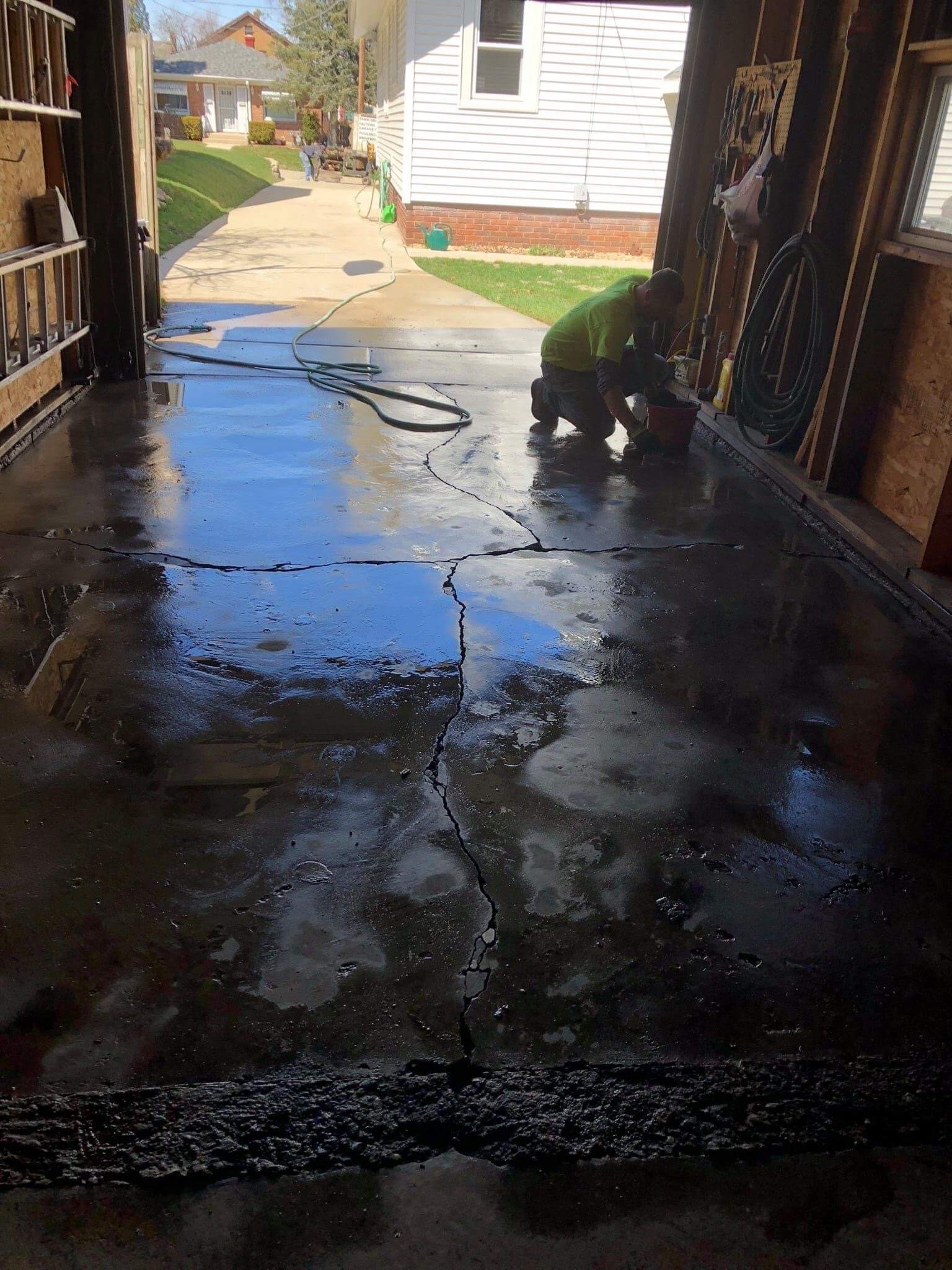 Worker Repairing Crack in Garage Floor — Rockford, IL — Northern Illinois Concrete Lifting