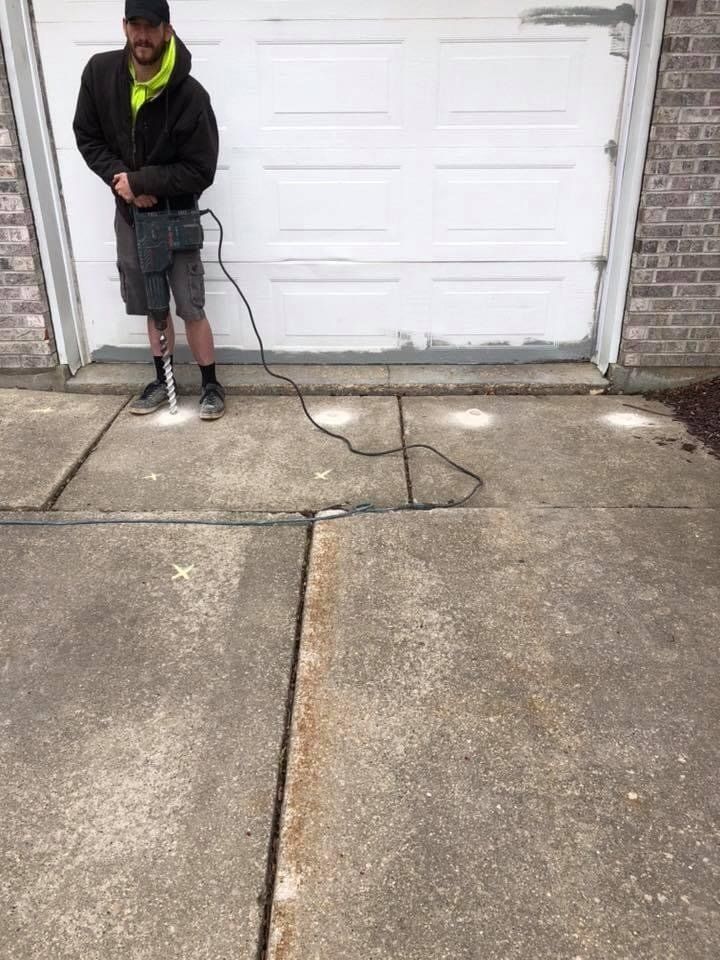 Worker in Front of Crack in Garage Driveway — Rockford, IL — Northern Illinois Concrete Lifting