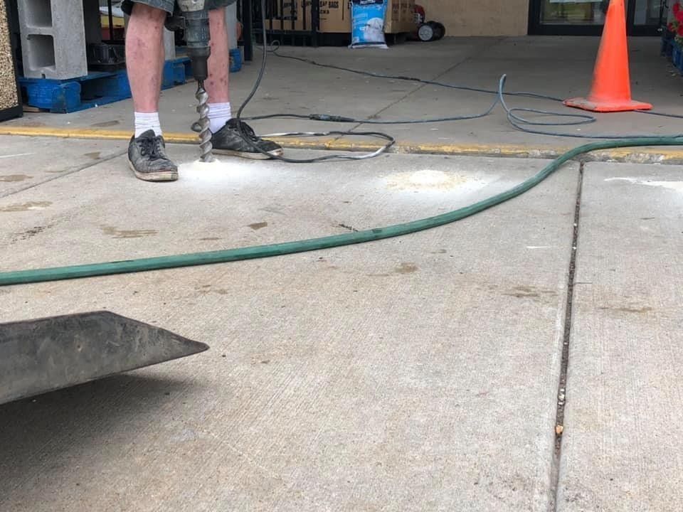 Worker Repairing Commercial Front Entrance — Rockford, IL — Northern Illinois Concrete Lifting