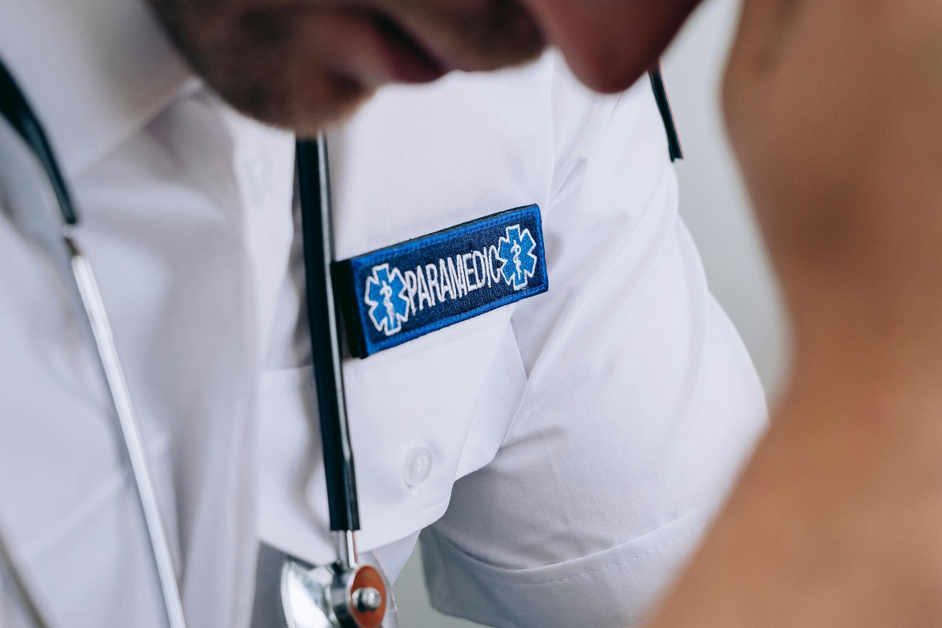 Paramedic's uniform with a blue badge, stethoscope, and a close-up view of a medical professional.
