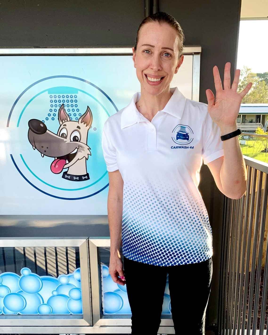 A Woman Is Standing In Front Of A Sign With A Dog On It — Carwash 44 In Caboolture, QLD
