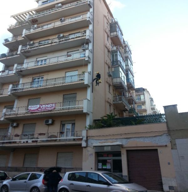 operaio che esegue un lavoro in quota su un palazzo