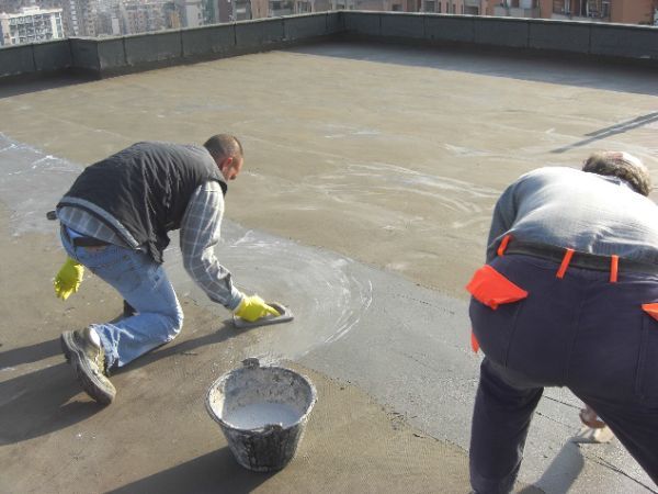 operai edili che eseguono un intervento di impermeabilizzazione