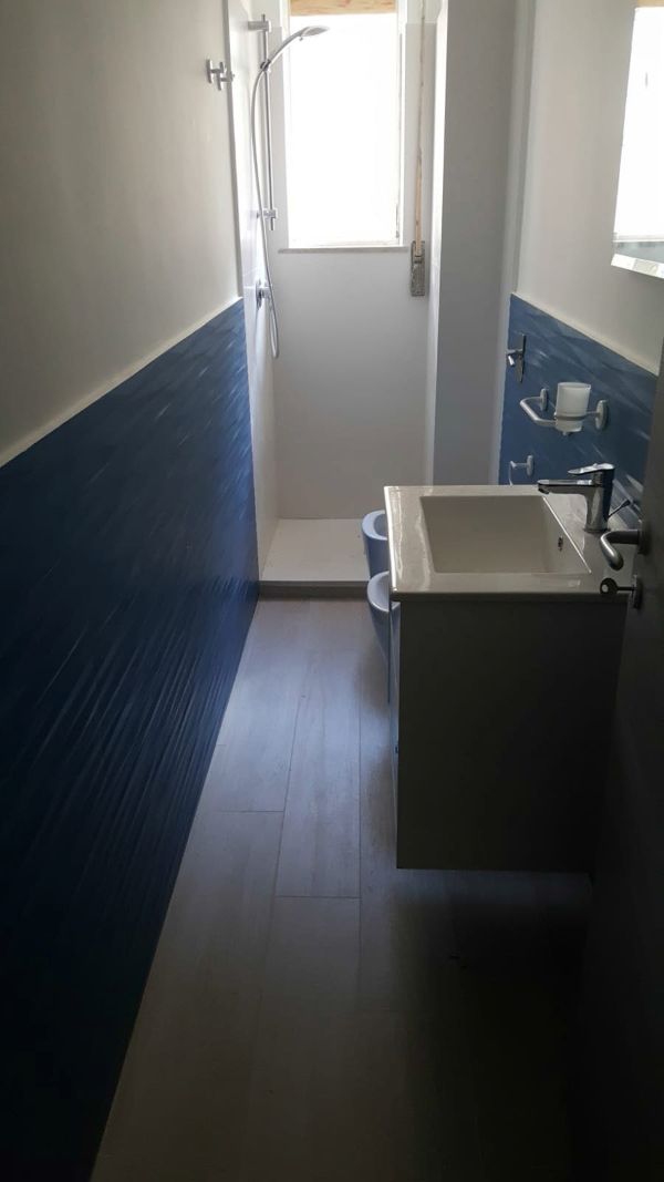 bagno con muro blu e lavandino squadrato