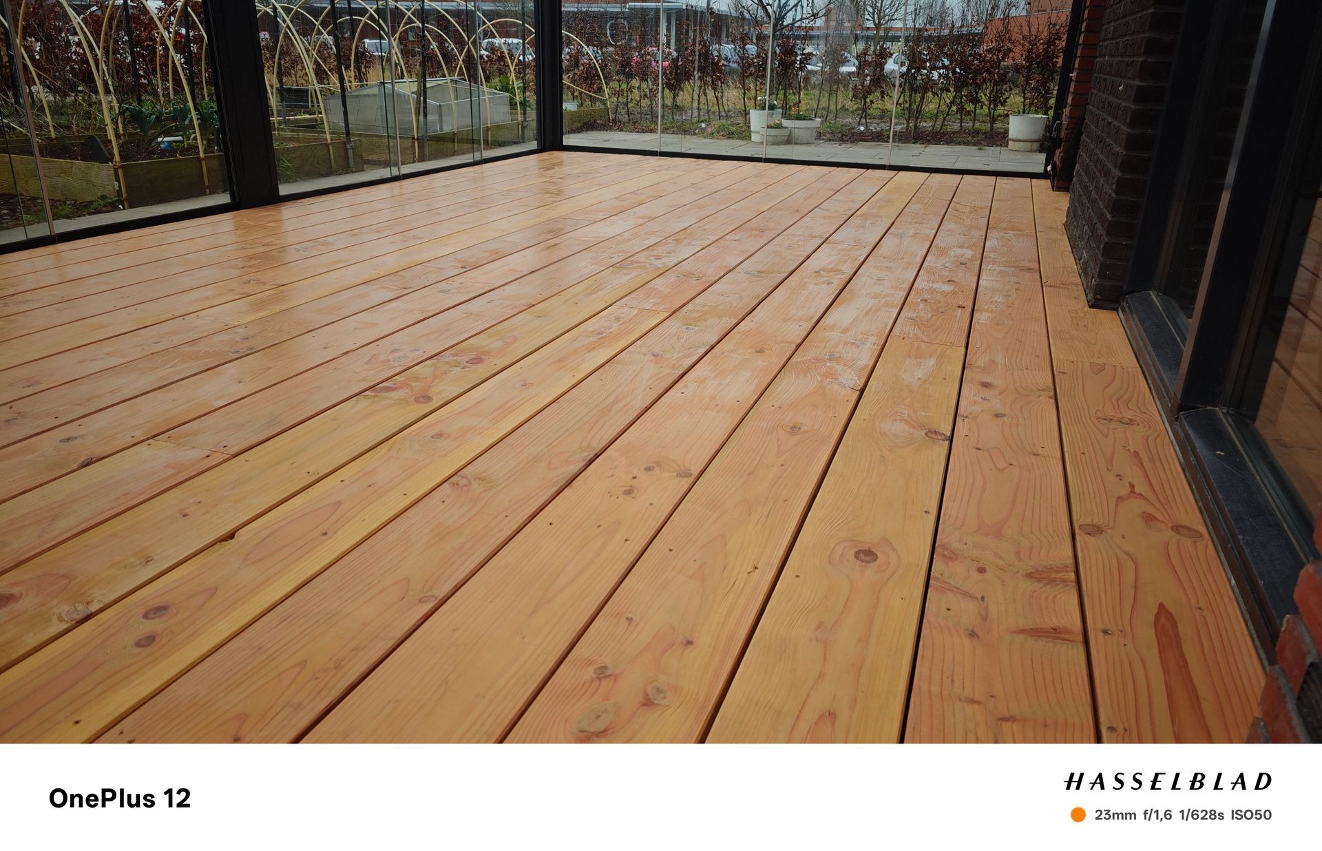 Lichtbruin houten terras met horizontale planken, vlakbij de buitenkant van een gebouw.