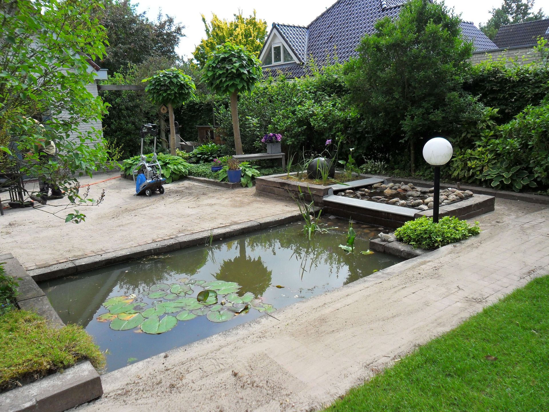 Een aangelegde achtertuin met een vijver.