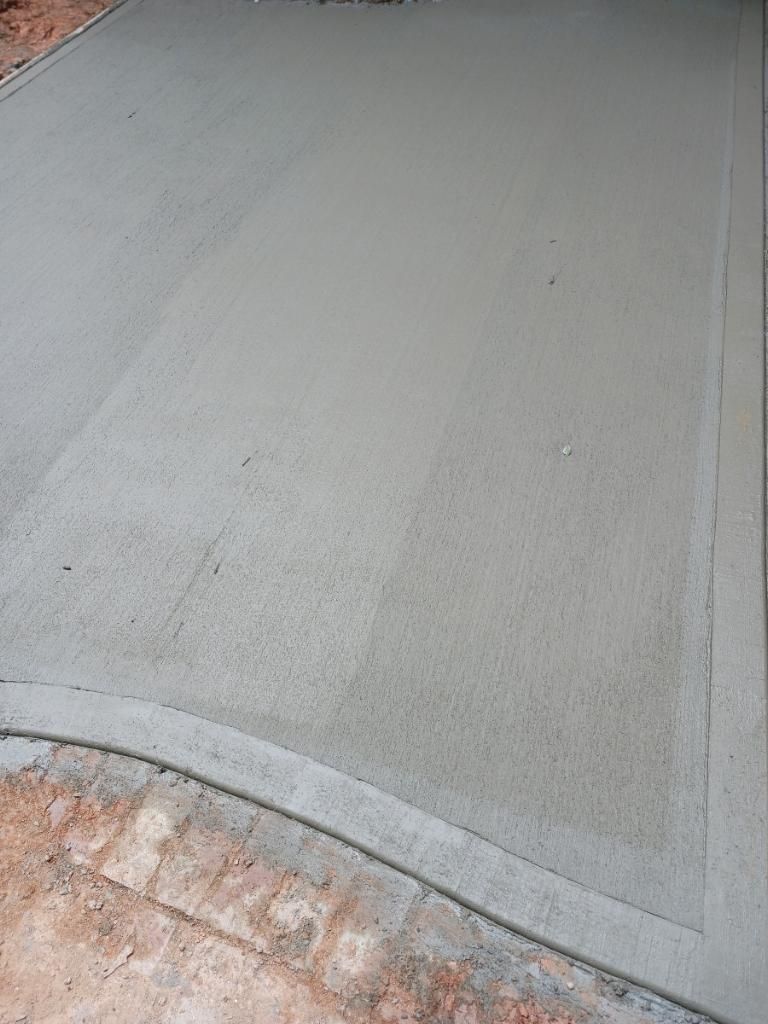 Freshly poured concrete surface with a curved edge.