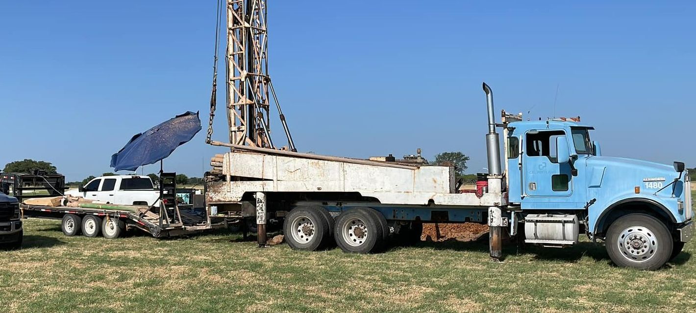 A blue truck with a drilling rig attached to it is parked in a field — Seminole, TX — Shpuetz Drilling