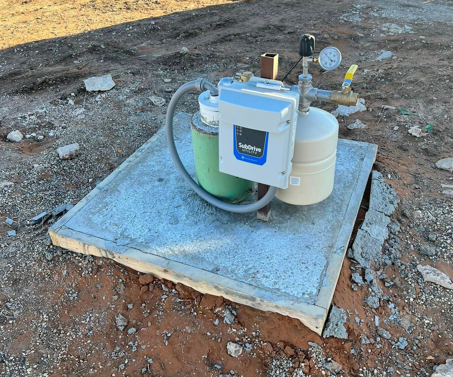 A water pump is sitting on top of a concrete slab in the dirt — Seminole, TX — Shpuetz Drilling