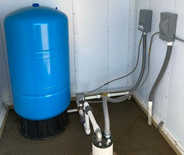 A blue water tank is sitting in a room next to pipes — Seminole, TX — Shpuetz Drilling