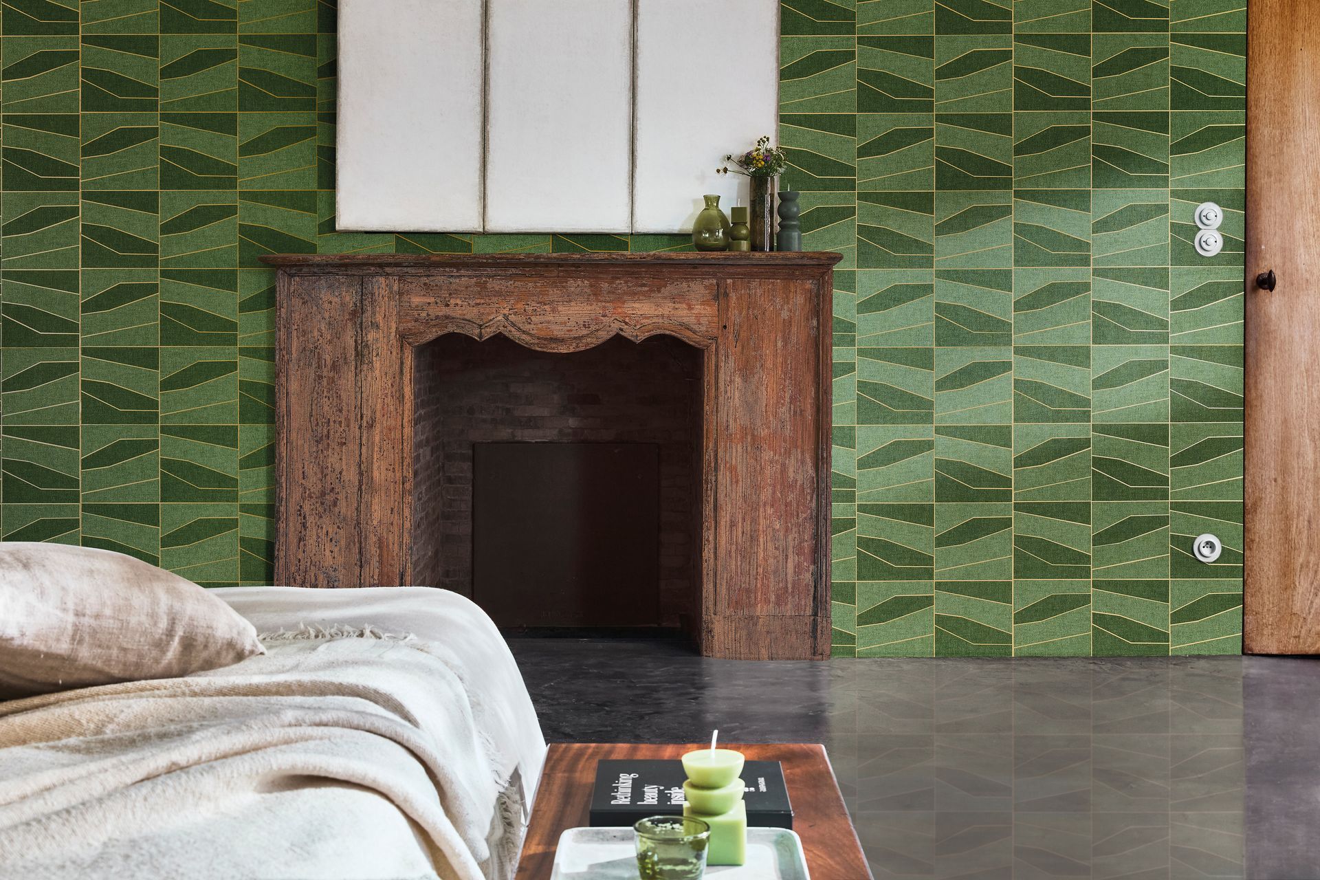 Parete piastrellata verde, camino anticato, letto con coperta e porta rivestita in legno.