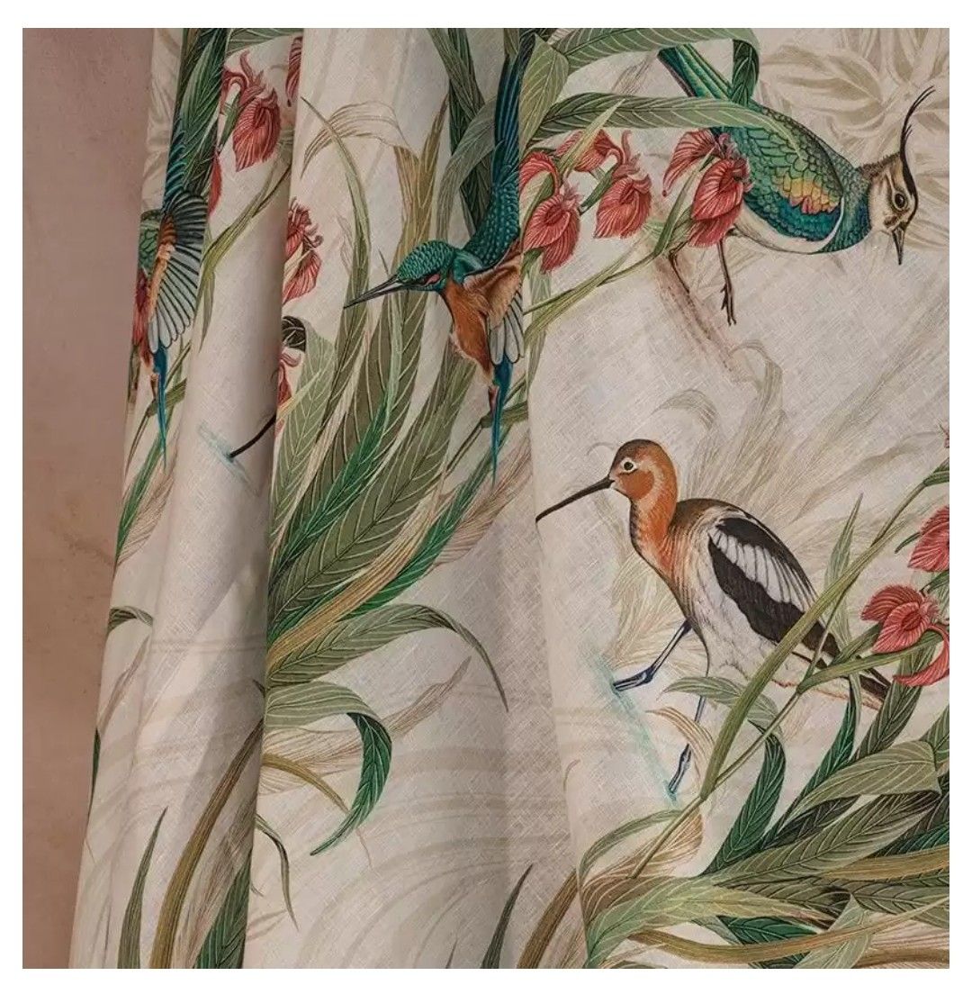 Tessuto per tende con illustrazioni di colibrì, uccelli e piante in verde, arancione e bianco.