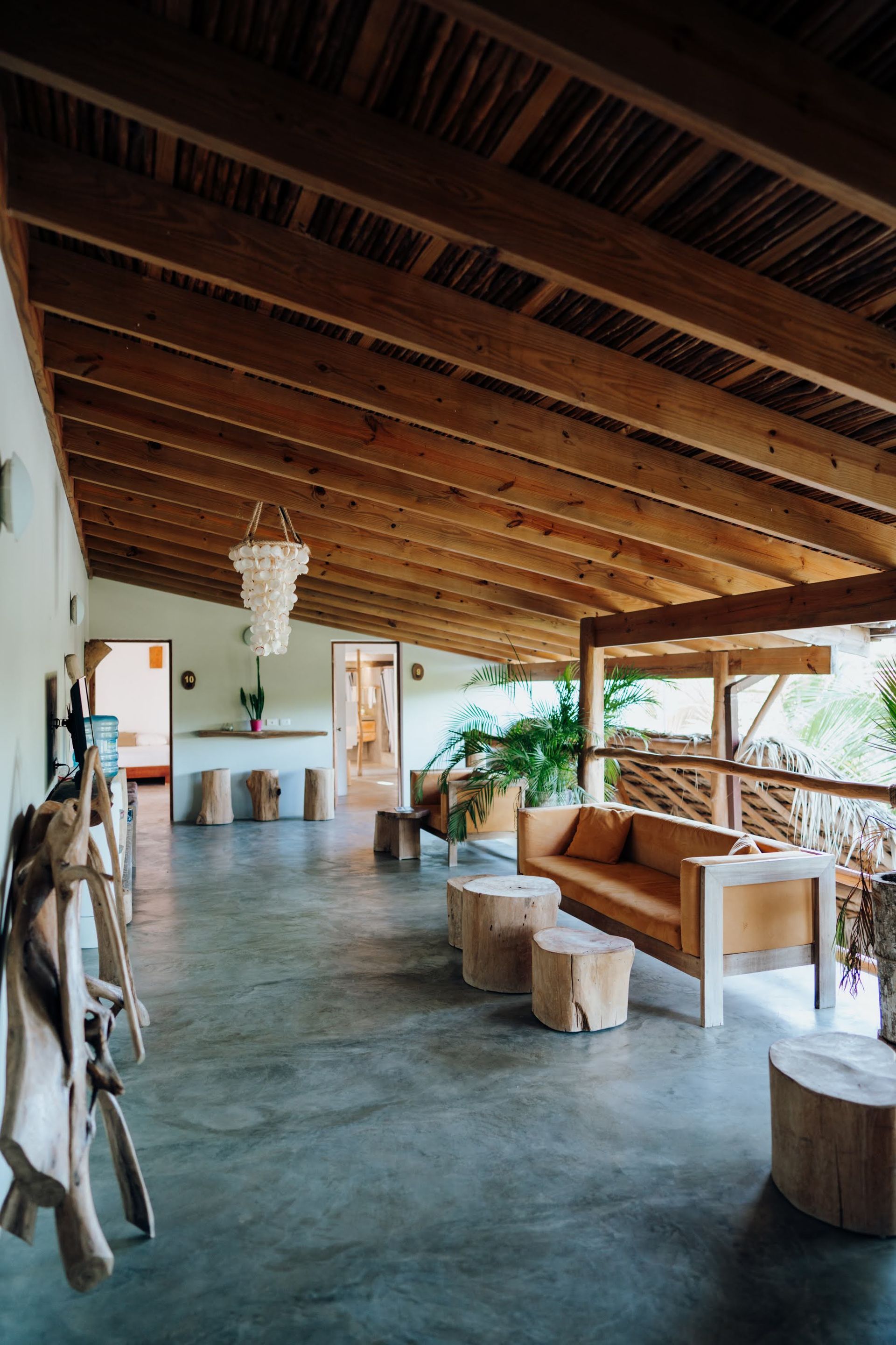 Covered patio with wooden ceiling, furniture, and concrete floor.