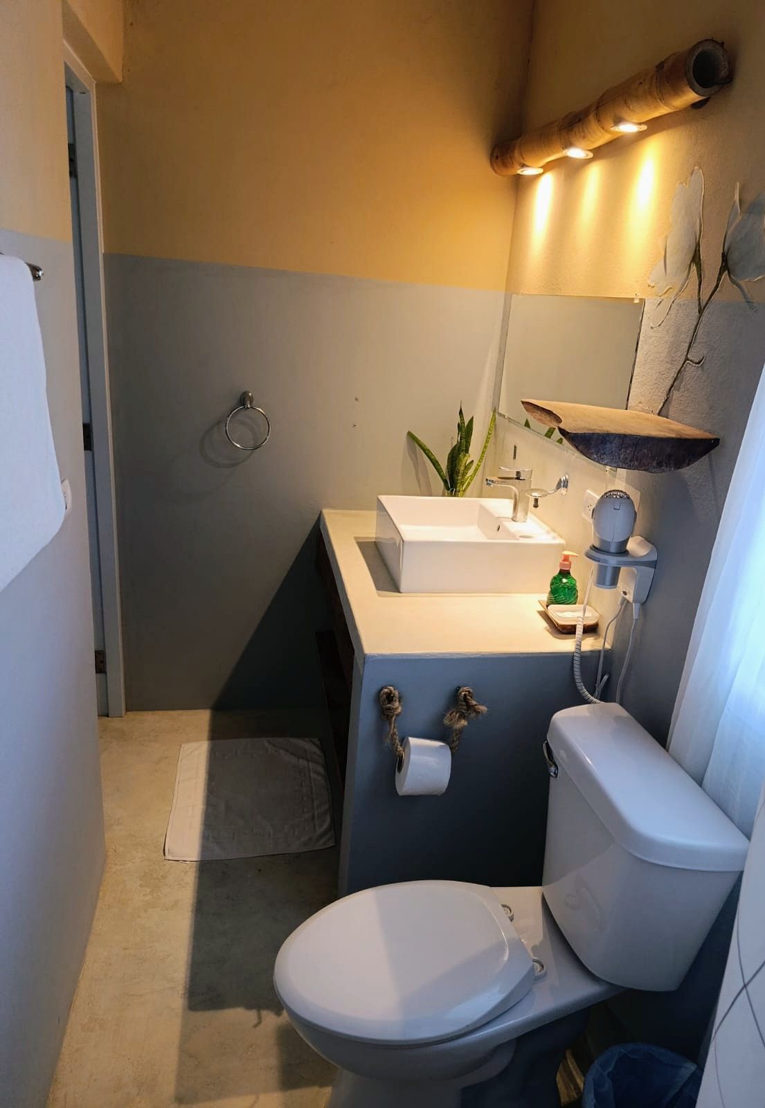 Bathroom with blue and beige walls, white sink and toilet.
