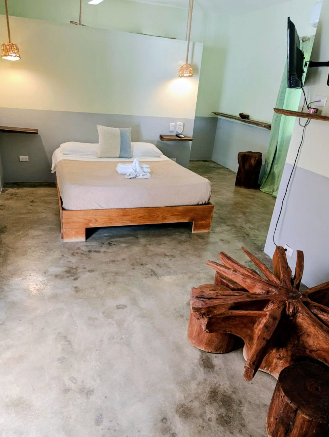 Bedroom with bed, rustic wooden furniture, and light gray walls.