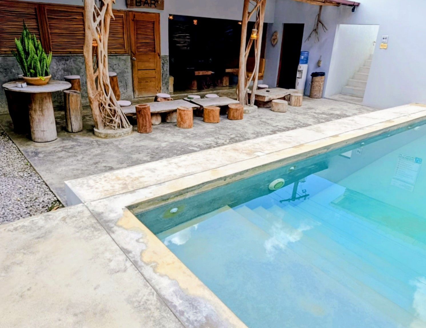 Poolside seating area with pool, tables, and a bar area.