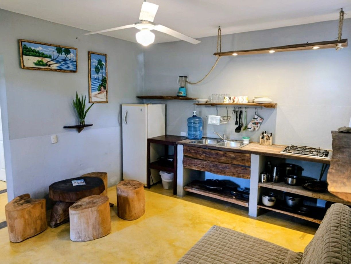 Small kitchen with wood accents, yellow floor, blue walls, and rustic furniture.