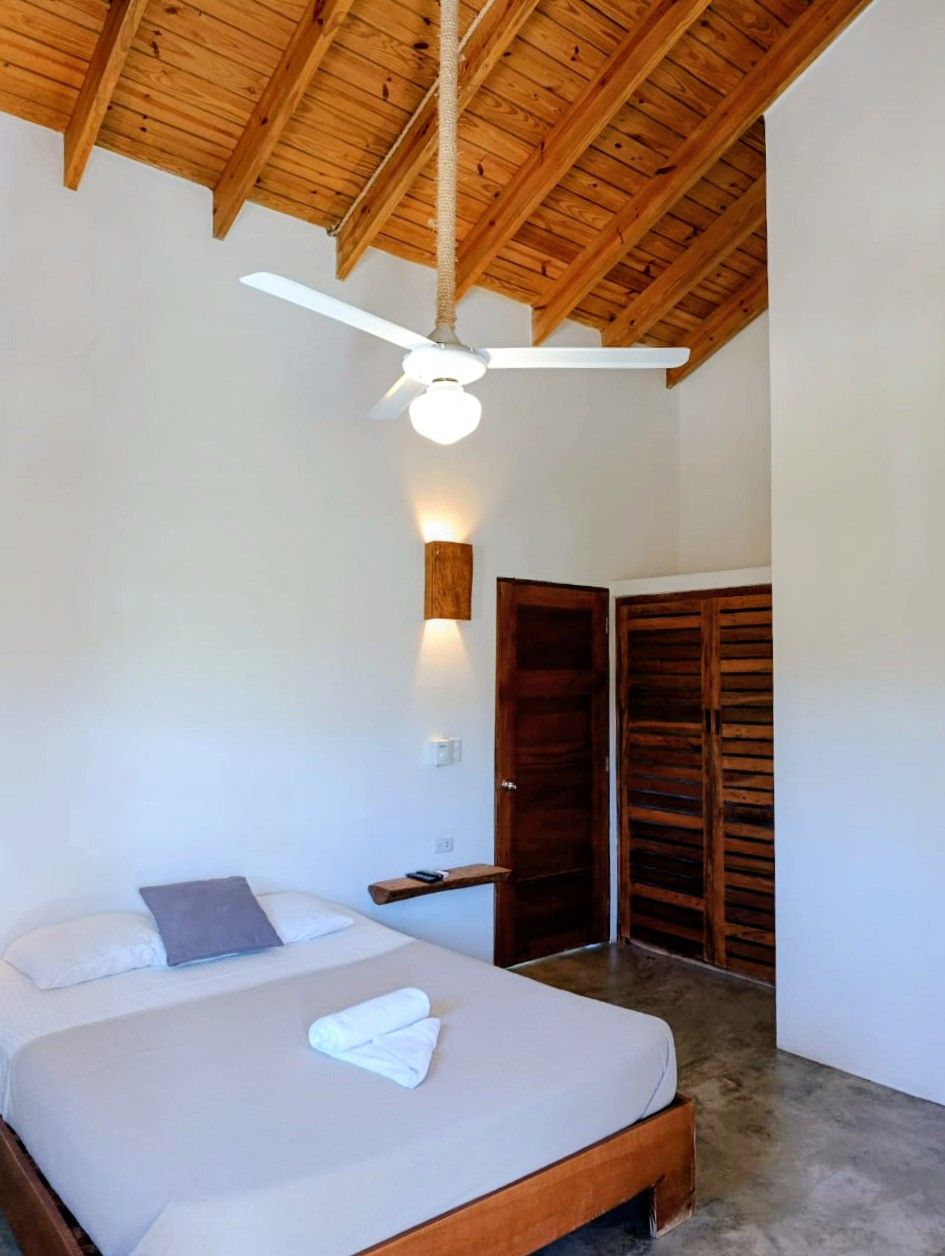 Bedroom with bed, closet, wood ceiling, and ceiling fan.