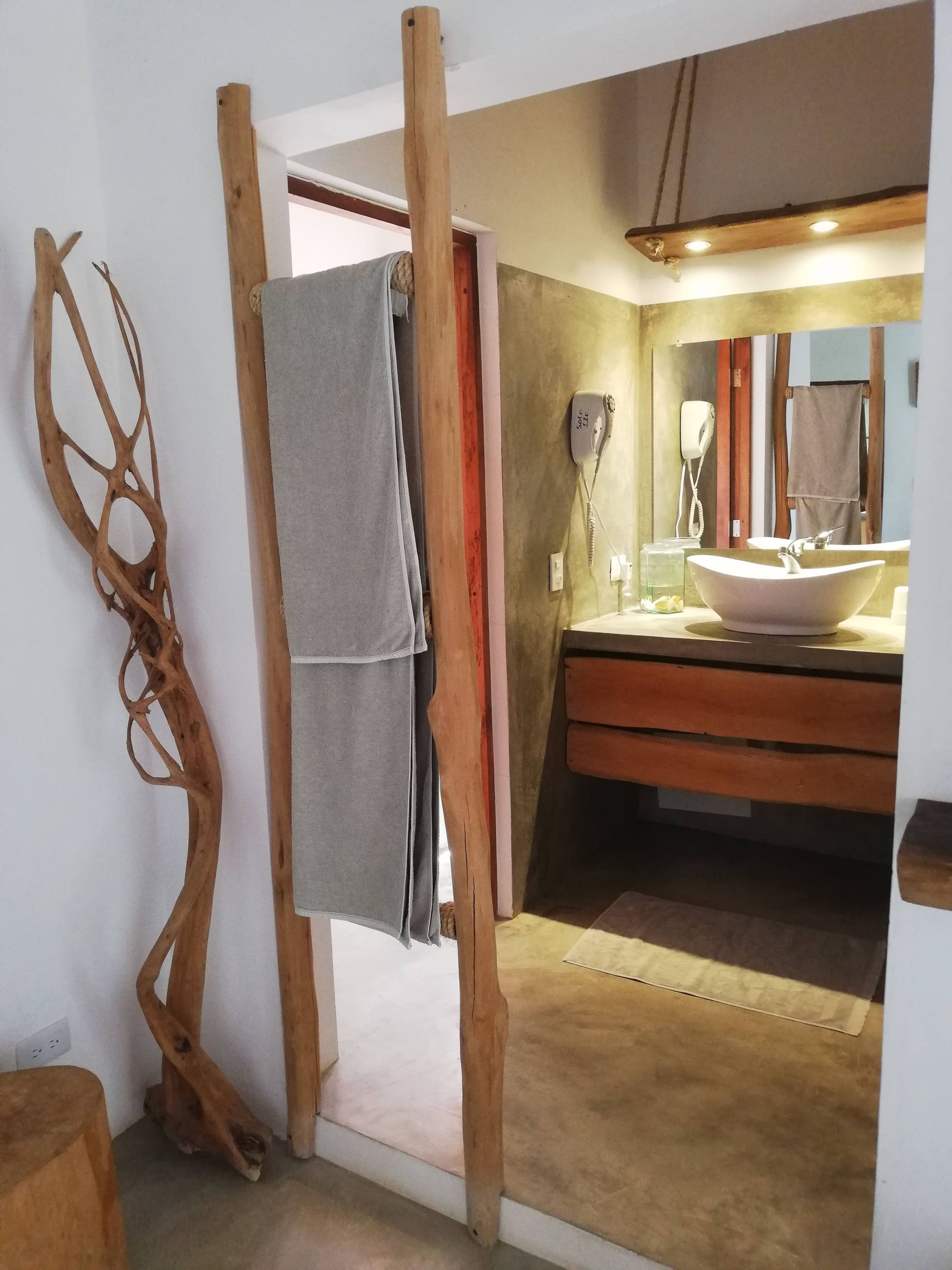 Rustic bathroom with a wooden ladder holding a gray towel.