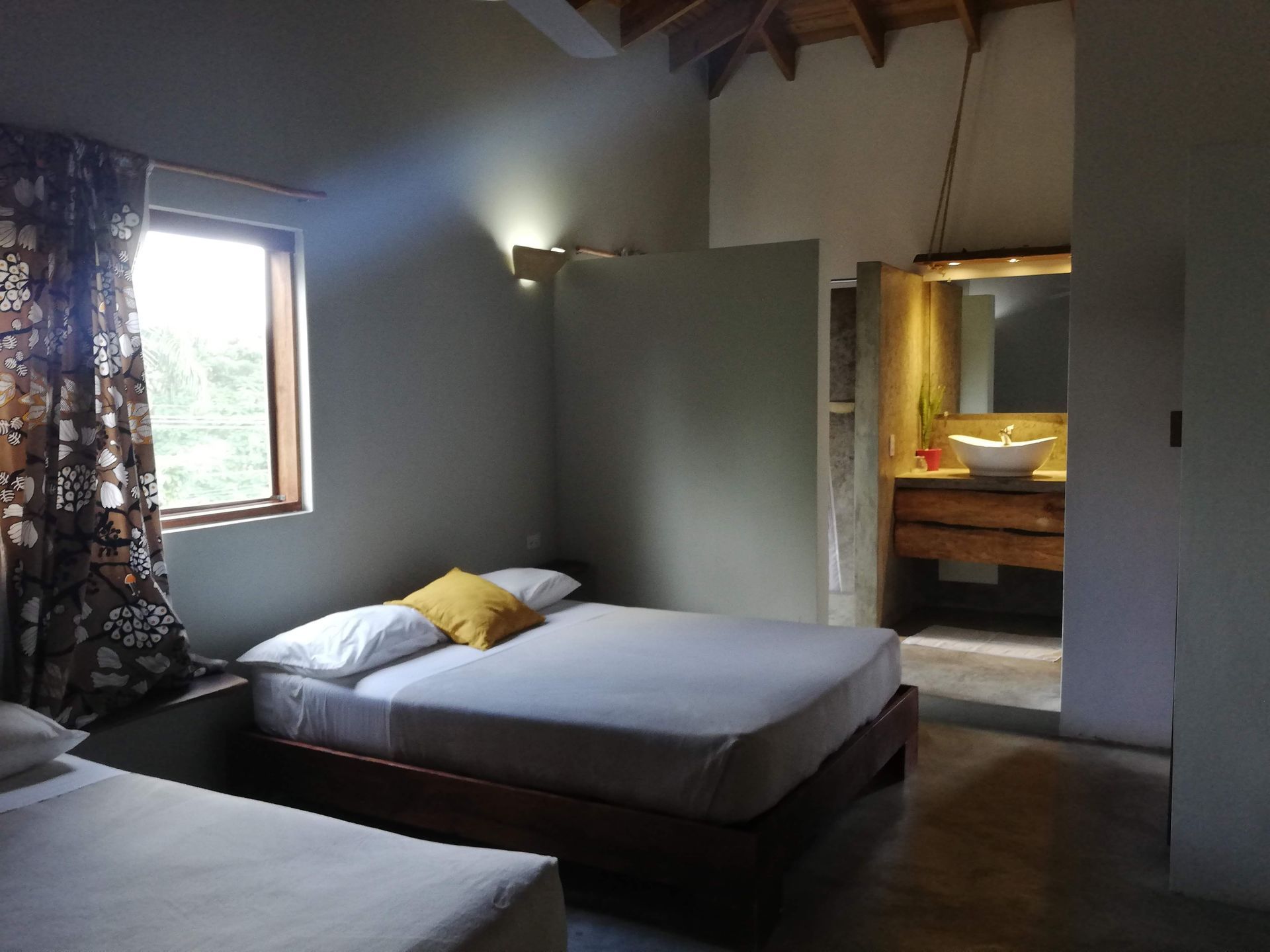 Bedroom with two beds, window, and open bathroom.