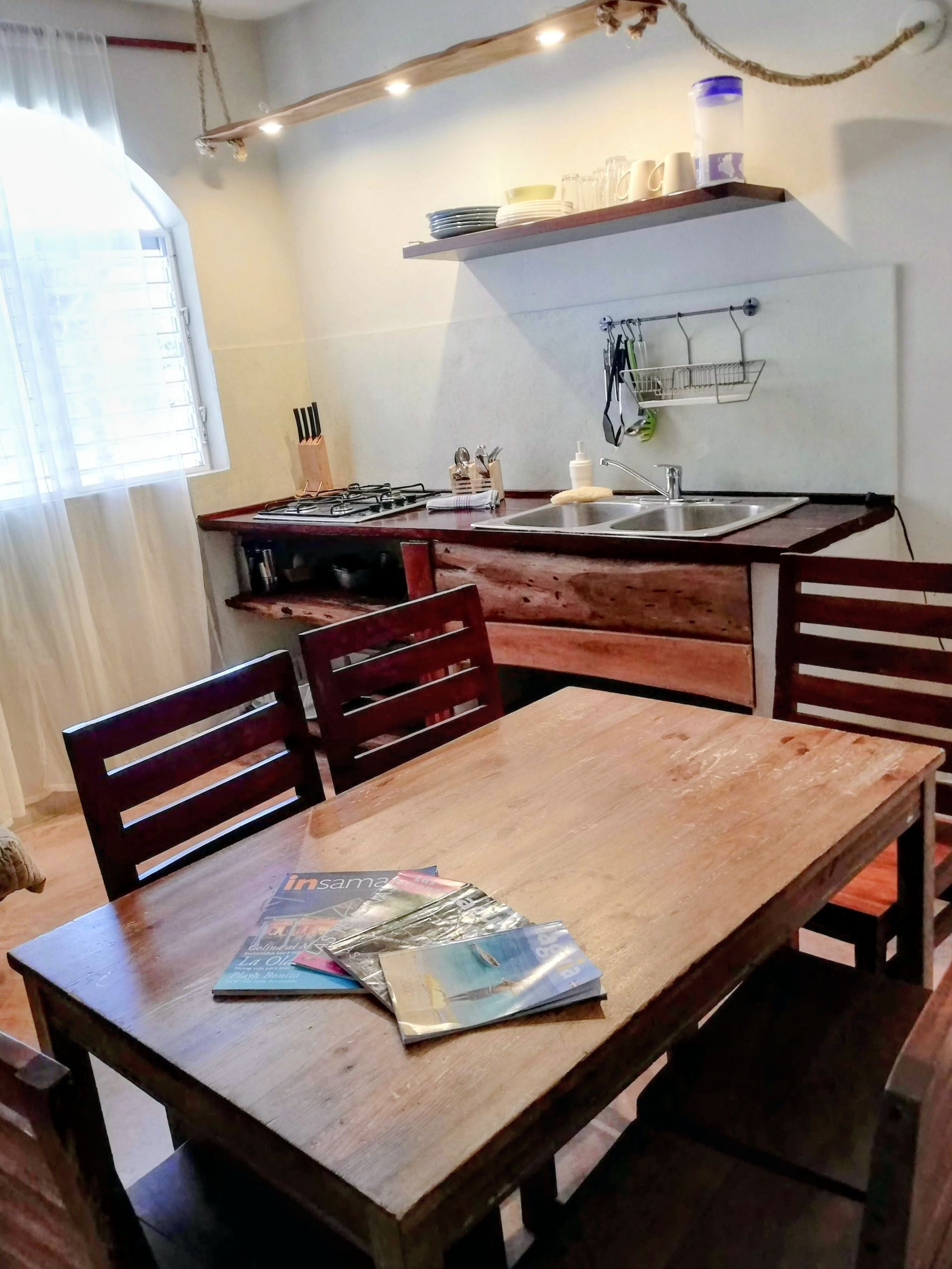 Small kitchen and dining area with wooden furniture and decor.