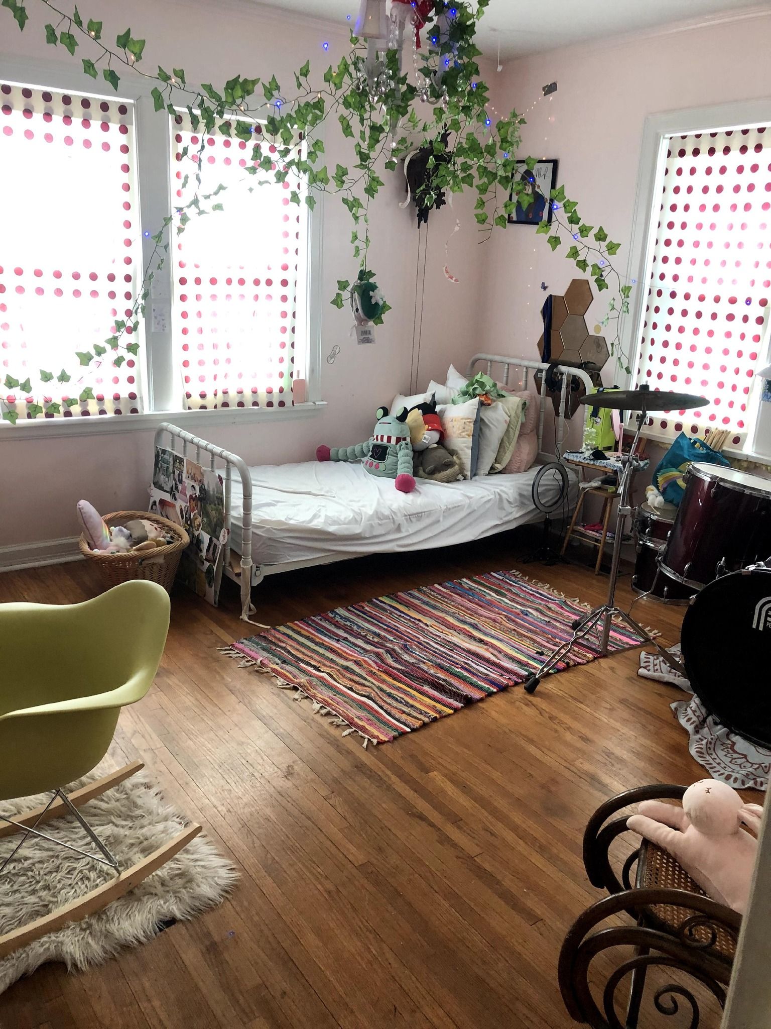 A bedroom with a bed , rocking chair , and a drum set.