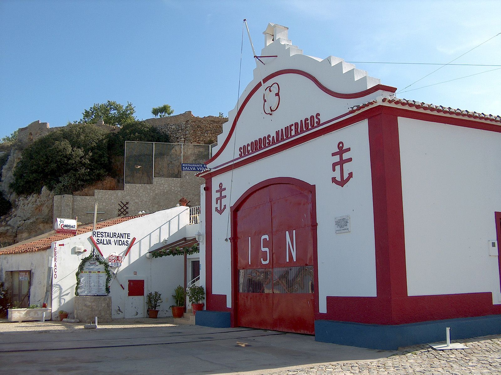 White and red building with large red door, 