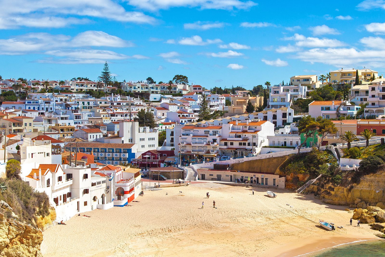 White buildings overlooking a sandy beach on a sunny day.