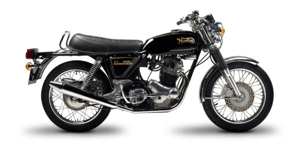 A black motorcycle is sitting on a white surface.