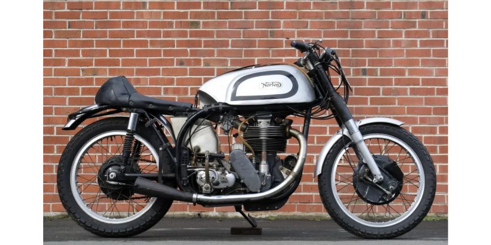 A motorcycle is parked in front of a brick wall.