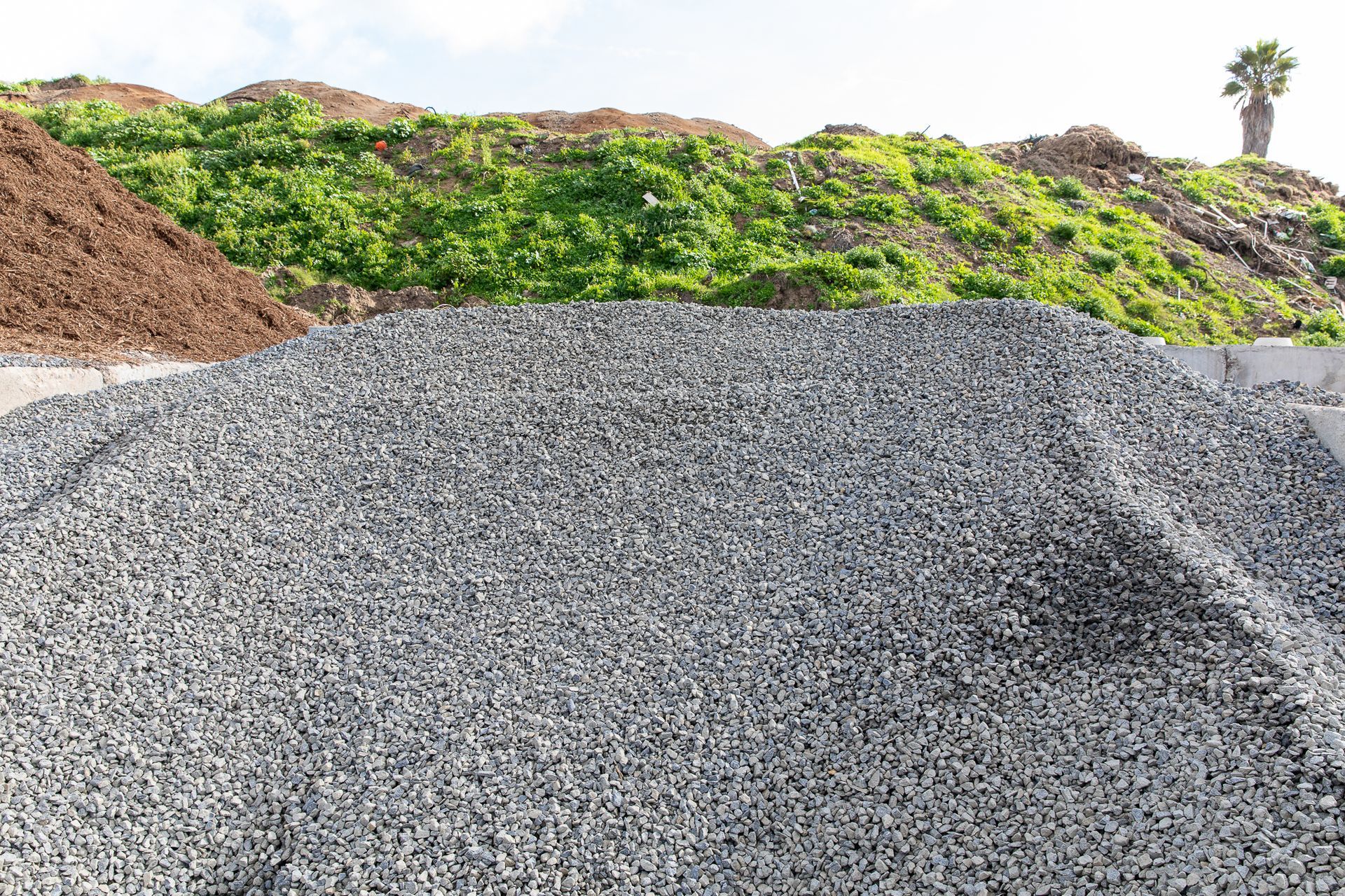 A pile of gravel is sitting on top of a pile of dirt.