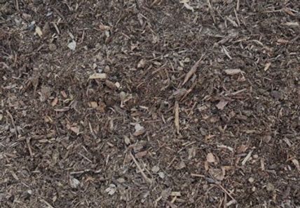 A pile of brown mulch is sitting on the ground.