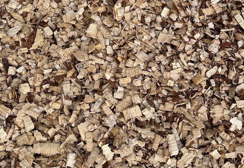 A pile of wood chips is sitting on the ground.