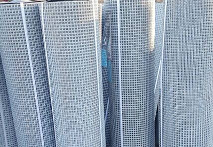 A bunch of rolls of wire mesh are stacked on top of each other.