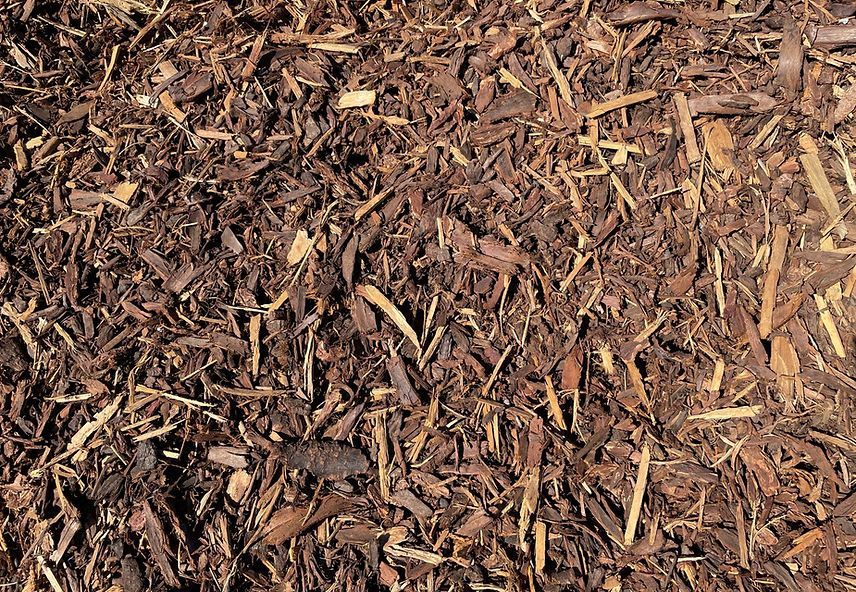 A pile of brown mulch is sitting on the ground