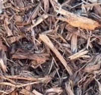 A pile of wood chips sitting on top of a pile of dirt.