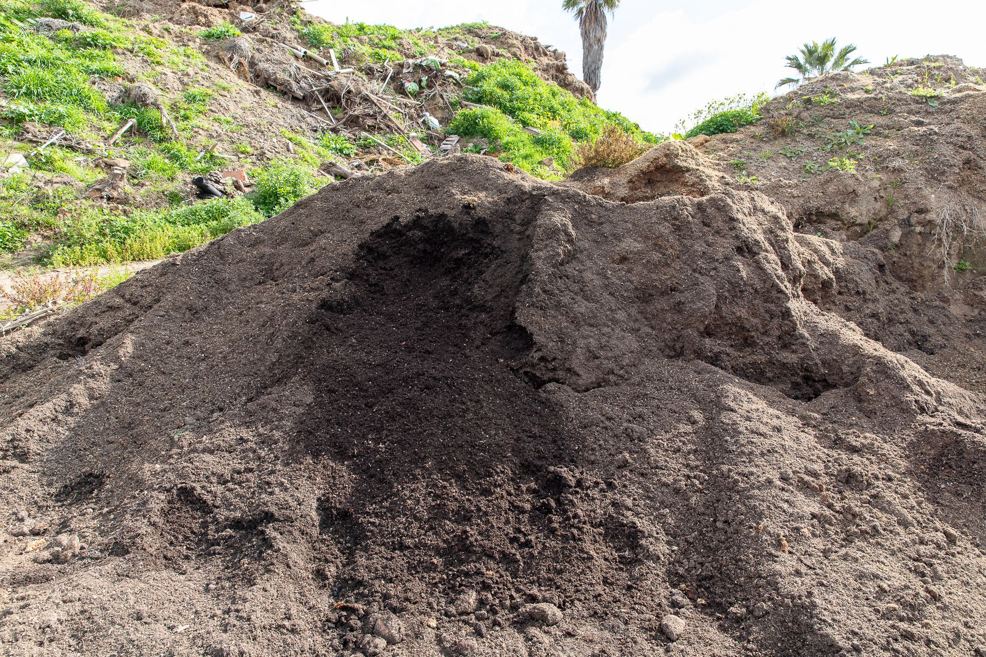 A large pile of dirt is sitting on top of a hill.