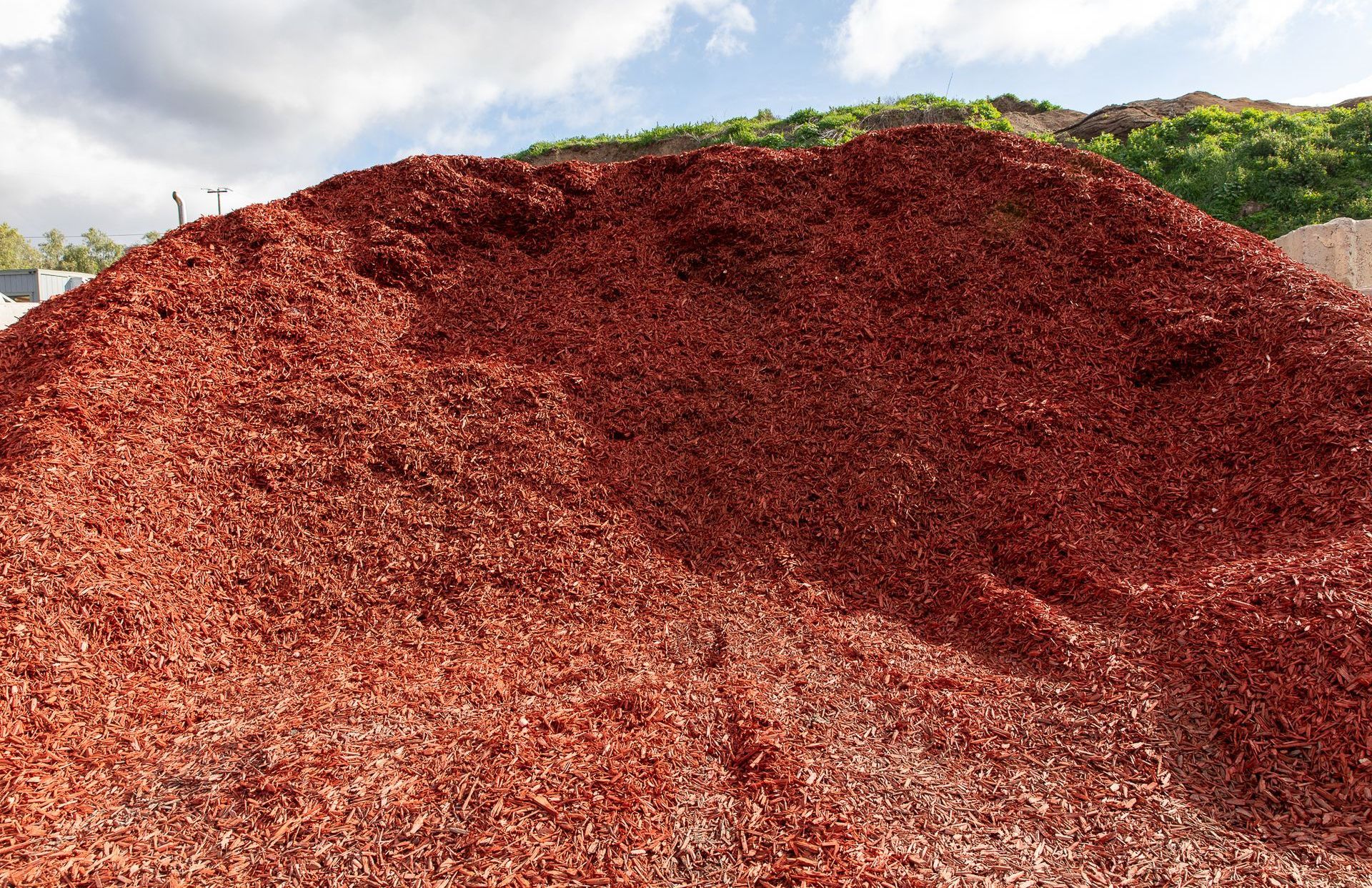 A large pile of red gravel is sitting on top of a hill