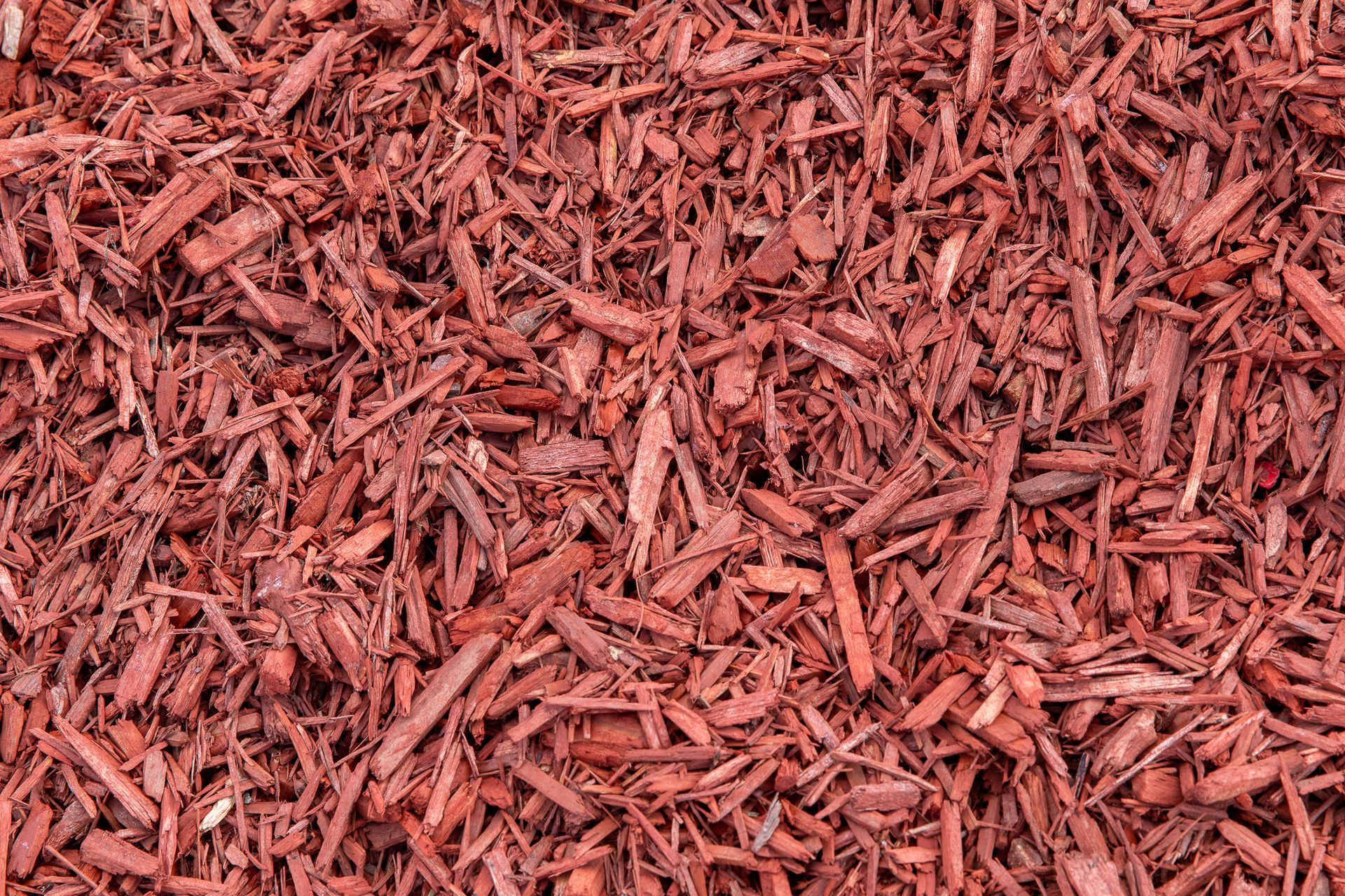 A pile of red mulch is sitting on the ground