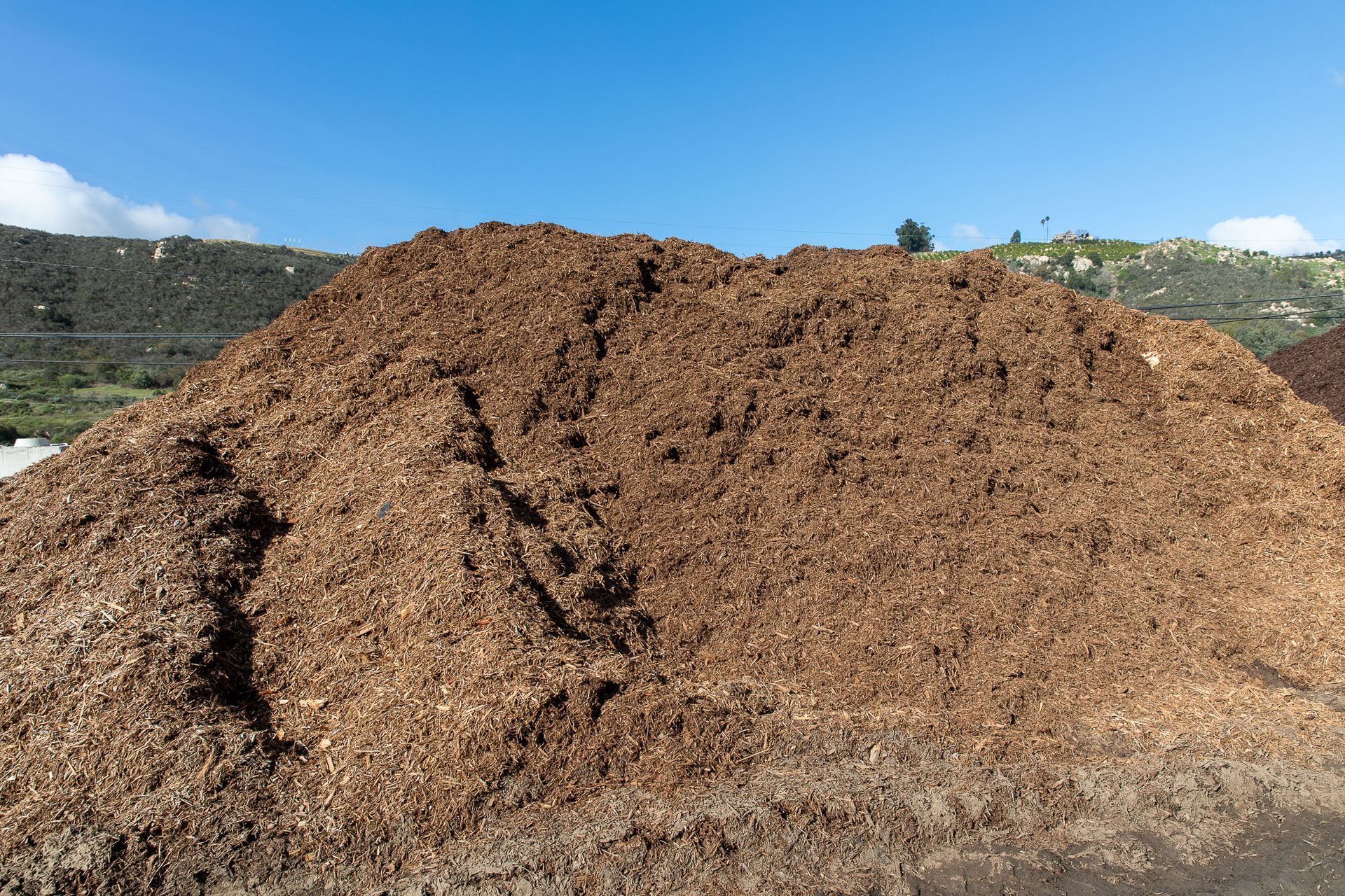 A large pile of dirt with mountains in the background